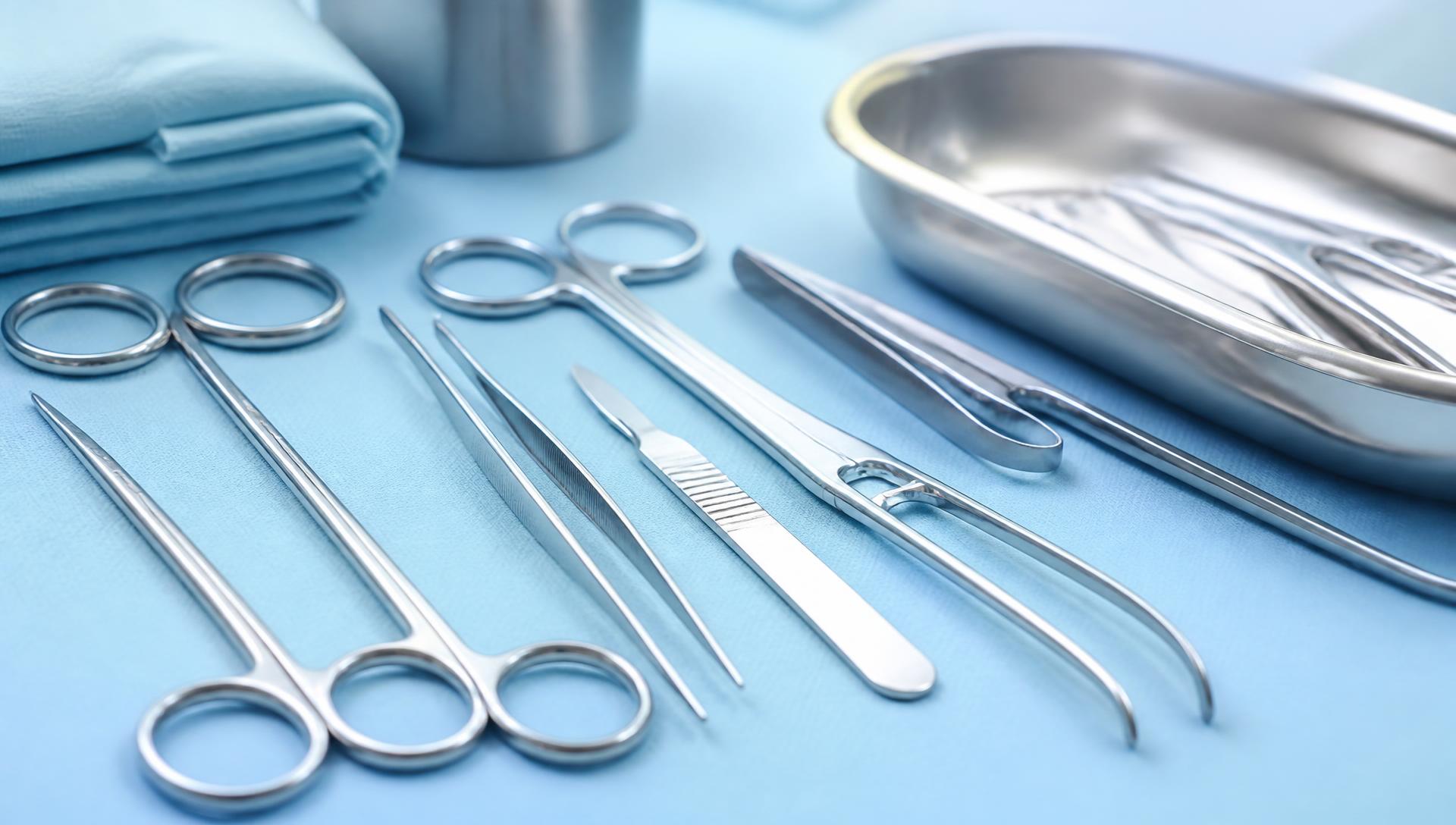 Sterile stainless steel surgical instruments arranged on a medical drape
